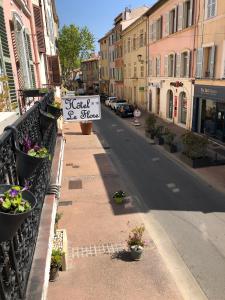 a street with a balcony with a sign on it at Hotel Le Flore in Fréjus