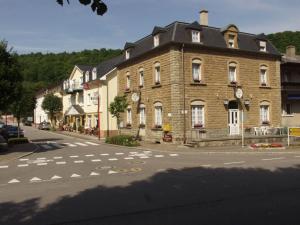 um grande edifício de tijolos numa rua com uma faixa de pedestres em Logis Hotel-Restaurant Dimmer em Wallendorf pont