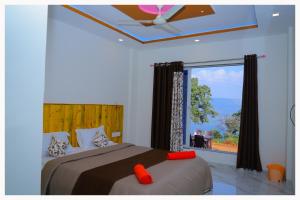 um quarto com uma cama e uma janela grande em Sai Siddhigiri Villa em Mahabaleshwar