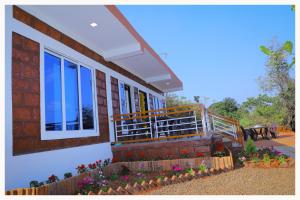 une maison avec balcon et fleurs dans une cour dans l'établissement Sai Siddhigiri Villa, à Mahabaleshwar