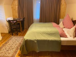 um quarto com uma cama com uma mesa e uma secretária em Vila Hubertus em Avrig