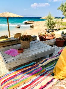 a picnic table on a beach with a view of the ocean at The Beachhouse Apartments in Vaia