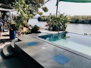 una piscina junto a un cuerpo de agua en Serene Waters Homestay Goa, en Panaji