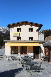 un edificio con mesas y sillas delante de él en Hotel Sfazù, en Poschiavo