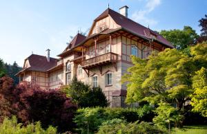 une grande maison avec un toit en gambrel dans l'établissement Jestřabí, à Luhačovice