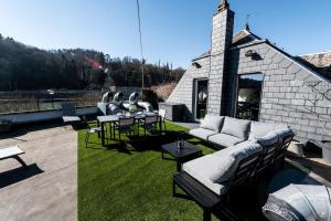 een patio met banken en tafels en een gebouw bij Les 3 chapeaux Dinant in Dinant