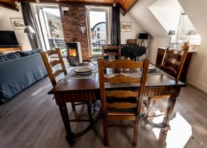 een eetkamer met een houten tafel en stoelen bij Les 3 chapeaux Dinant in Dinant