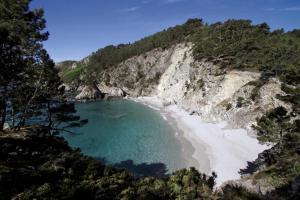 een strand aan de kant van een klif bij Hôtel Morgat Le Grand Hôtel De La Mer in Crozon