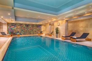 una piscina in un hotel con sedie e un dipinto di National by Stellar Hotels, Yerevan a Yerevan