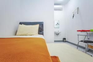 Tempat tidur dalam kamar di Shekinah Homestay & Cafe Waikabubak Mitra RedDoorz