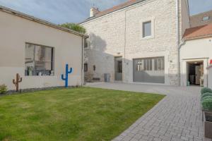 a house with a grass yard in front of a building at Charmes en Chambertin in Gevrey-Chambertin