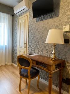 - un bureau avec une lampe et une chaise dans la chambre dans l'établissement Hotel Apostoli Garden, à Venise