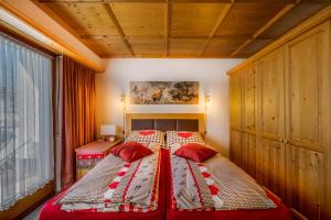 - une chambre avec un grand lit et des oreillers rouges dans l'établissement Apartments Olympiastraße, à Seefeld in Tirol