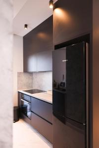 cocina con nevera negra y fogones en D-Palace Apartments-Olive tree, en Donji Zemunik