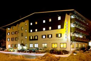 un gran edificio con coches estacionados frente a él en Hotel Linde, en Wörgl