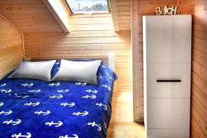 een slaapkamer in een tiny house met een bed en een raam bij Nadmorskie Klimaty - Domki Całoroczne in Stegna