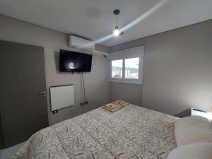 a bedroom with a bed and a flat screen tv at Departamento Torre Murguía in San Salvador de Jujuy