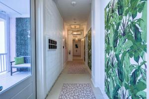 um corredor com um mural de plantas na parede em The Oleander Hotel Room 6 em Galveston