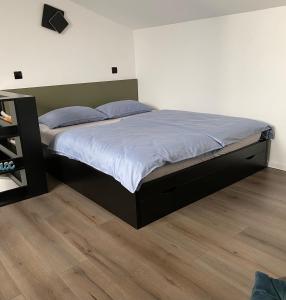 um quarto com uma cama grande e almofadas azuis em Strawberry Apartments City Center em Novi Sad