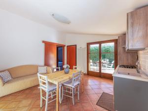 eine Küche und ein Wohnzimmer mit einem Holztisch und Stühlen in der Unterkunft Holiday Home Alma by Interhome in Castiglione della Pescaia