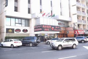 una strada trafficata con auto parcheggiate di fronte a un edificio di Palm Beach Hotel a Dubai