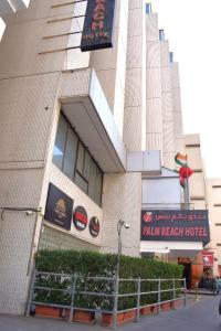 un edificio con un cartello hotel sulla spiaggia di palme di Palm Beach Hotel a Dubai