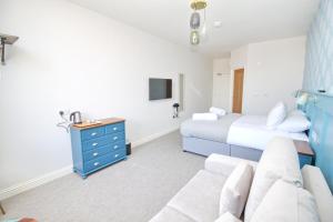 ein Schlafzimmer mit einem Bett und einer blauen Kommode in der Unterkunft CarterCo Rooms in Portsmouth