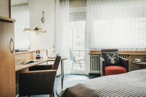 a hotel room with a desk and a bed and a window at Hotel Koch in Bad Liebenzell