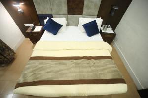 a bedroom with a large bed with blue pillows at The Byke Heritage Adventure Park & Resort, Matheran in Matheran