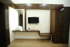 a room with a tv on a wall with a desk at The Byke Heritage Adventure Park & Resort, Matheran in Matheran