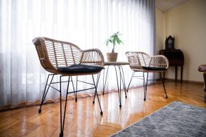 three rattan chairs and a table in a room with a window at Green House - Douro in Peso da Régua