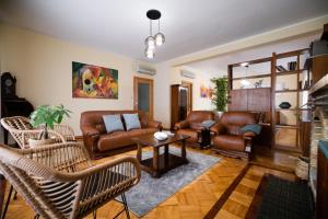 a living room with leather furniture and a table at Green House - Douro in Peso da Régua