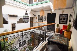 Zimmer mit einem Balkon mit Tisch und Stühlen in der Unterkunft Riad Vis Ta Vie in Marrakesch