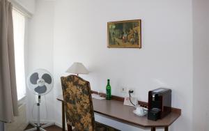 Cette chambre comprend un bureau avec une chaise et un ventilateur. dans l'établissement Hotel & Restaurant Sternen Köniz bei Bern, à Berne