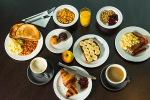 a table with plates of breakfast foods and cups of coffee at Holiday Inn Express Southampton West, an IHG Hotel in Southampton