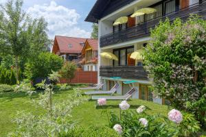 ein Haus mit einem Garten mit Stühlen und Blumen in der Unterkunft Hotel Jakob in Füssen