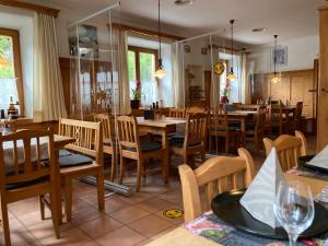 una sala da pranzo con tavoli e sedie in legno di Hotel Kammerhof a Mariastein