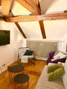 a living room with a couch and chairs and a tv at Ferienwohnung Nepomuk in Landshut