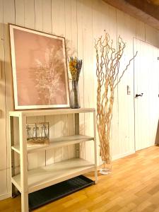 a shelf with vases and a picture on a wall at Ferienwohnung Nepomuk in Landshut