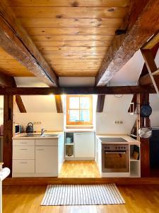 a kitchen with white appliances and a wooden ceiling at Ferienwohnung Nepomuk in Landshut