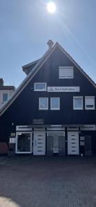 un bâtiment noir avec des portes et des fenêtres blanches dans l'établissement Hotel Stadt Soltau, à Soltau