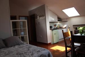 a room with a bed and a kitchen with a table at Apartamentos Los Hidalgos in Santillana del Mar