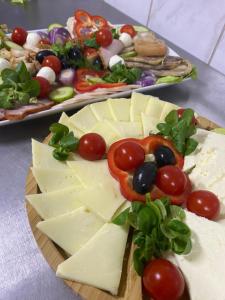 une assiette de fromage et de légumes sur une table dans l'établissement Pensiunea LUKA Slanic Moldova, à Slănic-Moldova