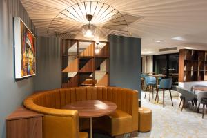 a waiting room with a table and chairs and a shelf at Crowne Plaza Manchester City Centre, an IHG Hotel in Manchester