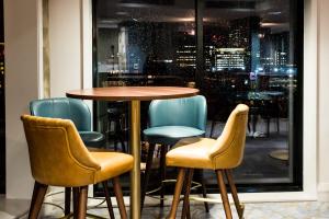 a table and chairs in front of a window at Crowne Plaza Manchester City Centre, an IHG Hotel in Manchester