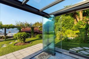 a glass extension of a house with a view of a garden at Hotel Il Perlo in Bellagio