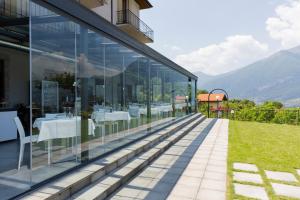 a glass house with a view of the mountains at Hotel Il Perlo in Bellagio