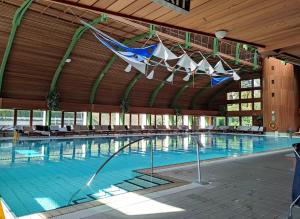 a large swimming pool with a large wooden building at Spa Residence Carbona Apartment 105 in Hévíz