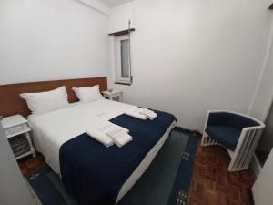 1 dormitorio con 1 cama y 1 silla azul en Cardume House by Hi Alentejo, en Sines