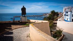 Una estatua de un hombre parado sobre una pared en Cardume House by Hi Alentejo, en Sines